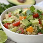 Ensalada de quinoa y aguacate servida en bol, con tomate cherry y pepino